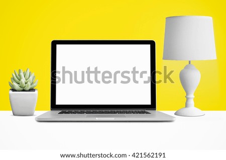 Laptop, lamps and potted cactus in the wall, blank screen with clipping path.