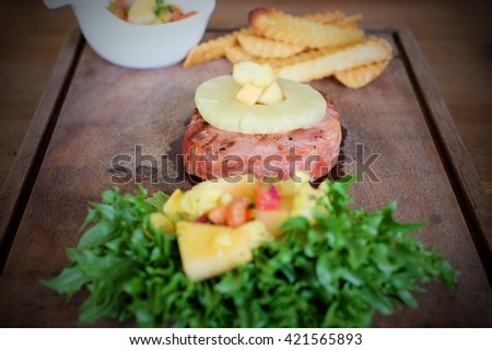 steak served with french frie and vegetables on an old wooden board