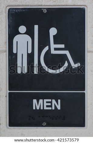 A sign for a mens bathroom posted on a brick wall