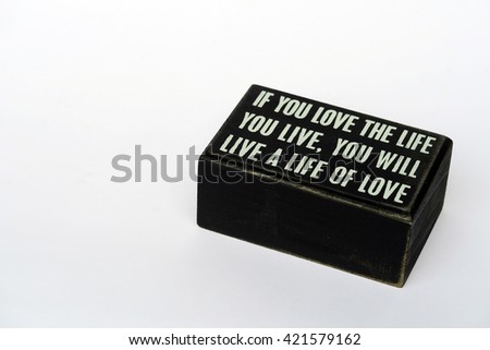 a wood block with quote "if you love the life you love, you will live a live for love" on white background                               