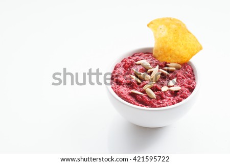 beet hummus in bowl on white background