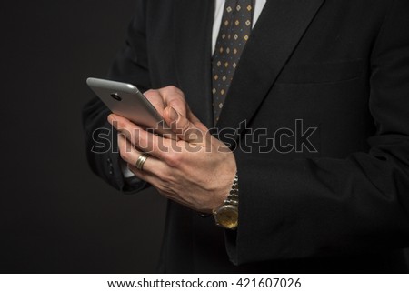 Closeup portrait of businessman typing something on mobile or smart phone. Studio shot of executive or corporate officer.