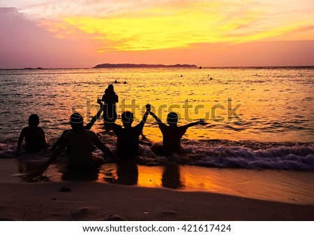Silhouette picture of young tourists have a happiness in sunset scene on the beach