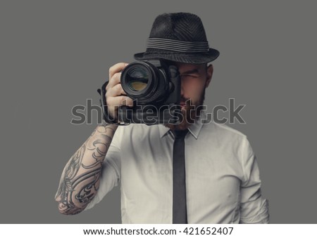 Photographer with digital camera isolated on grey background.
