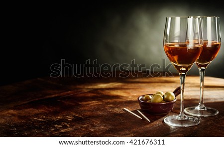 Profile Still Life of Two Glasses of Warm Sherry Wine on Rustic Wooden Table with Green Olives Appetizers with Copy Space Royalty-Free Stock Photo #421676311