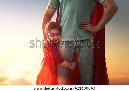 Happy loving family. Father and his daughter child girl playing outdoors. Daddy and his child girl in an Superhero's costumes. Concept of Father's day. Royalty-Free Stock Photo #421680043