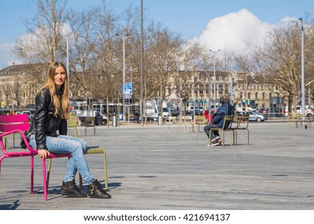 Beautiful young girl sitting in a chair on the street in the middle of Zurich, Switzerland