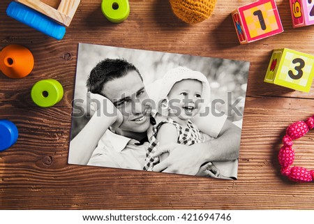 Fathers day composition. Black-and-white photo. Various toys. Young father enjoying time with child. Fathers day with daughter at home. Handsome father with little girl. Happy father and daughter.