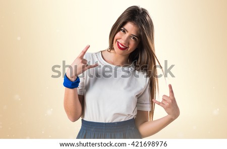 Young girl making horn gesture