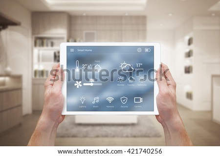 Smart home control on tablet. Interior of living room in the background. Royalty-Free Stock Photo #421740256