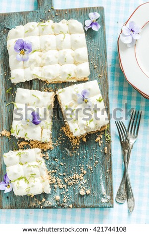taste of summer, key lime pie with flowers, sliced and served on wooden board
