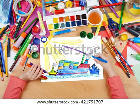 dry cargo ship with containers, transportation concept, child drawing, top view hands with pencil painting picture on paper, artwork workplace