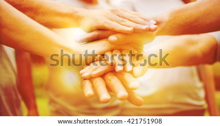 Happy volunteer family putting their hands together on a sunny day Royalty-Free Stock Photo #421751908