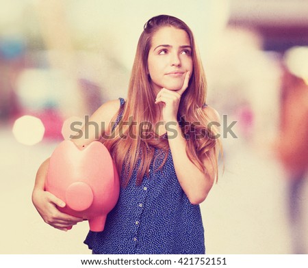 young woman thinking holding a piggy bank