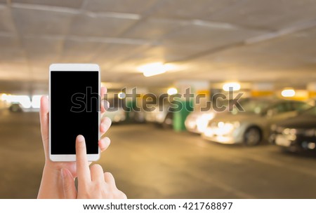 woman use mobile phone and blurred image of car park