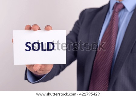 Man showing paper with SOLD text