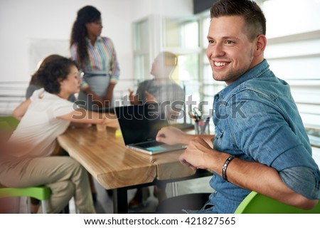 Image of a succesful casual business man using laptop during meeting