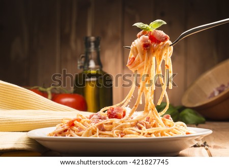 spaghetti with amatriciana sauce in the dish on the wooden table Royalty-Free Stock Photo #421827745