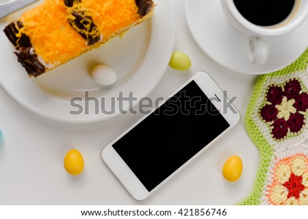 Top view of coffee cup, smart phone and cakes on wood background. Flat lay style.