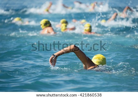 Triathlon swimmers inthe open sea,view from behind Royalty-Free Stock Photo #421860538