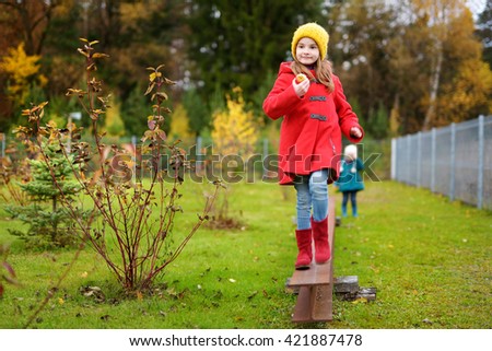 Cute little girl having fun on beautiful autumn day outdoors