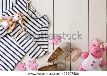 Flat lay children clothing and accessories on wooden background