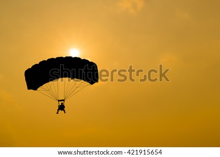 Young skydiver parachute in the air on sunset.