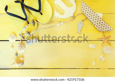 Beach accessories on yellow wooden background