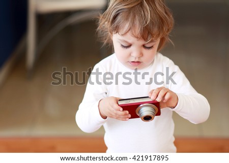 Little girl with compact photo camera