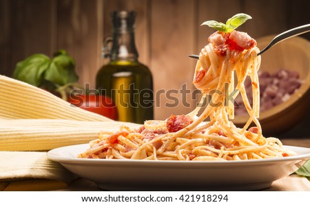 spaghetti with amatriciana sauce in the dish on the wooden table Royalty-Free Stock Photo #421918294