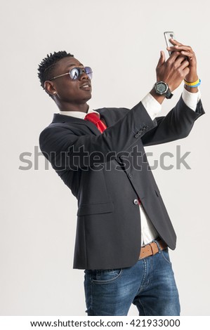 young man taking a selfie with a cell phone, isolated on white 