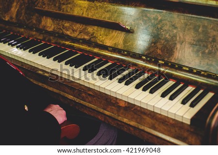Man sits at an old vintage piano