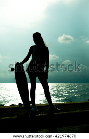 Silhouette of girl and skateboard 