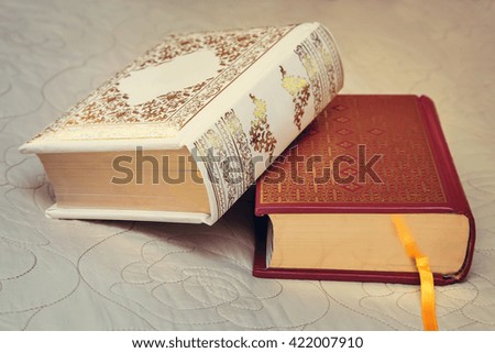 Two beautiful books lie on the couch in the background of a beautiful bedspread.