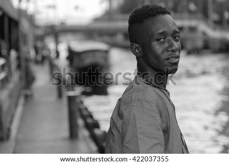 African man waiting boat next to river
