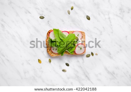 Sandwiches with spinach and radish on a marble