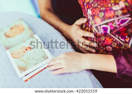Parents hands on the belly of the pregnant mother