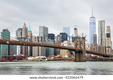 Manhattan skyline and Brooklyn Bridge on a cloudy day