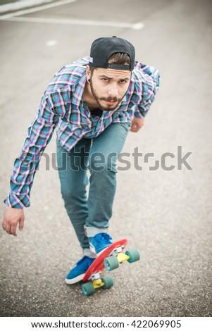 Stylish young guy on a red skateboard