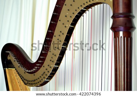 Closeup of the strings and mechanisms of a concert grand, pedal harp. Royalty-Free Stock Photo #422074396
