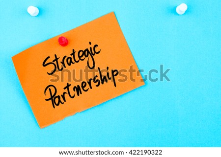Strategic Partnership written on orange paper note pinned on cork board with white thumbtack, copy space available