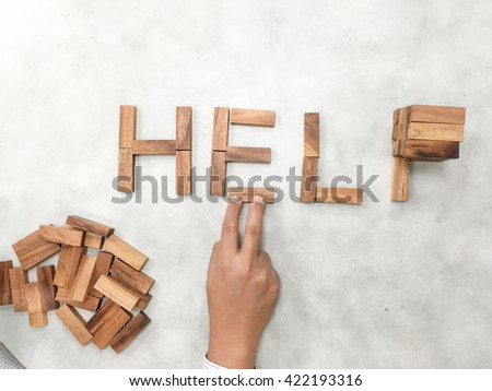 man's hand created word HELP by wooden blocks and put one block  - Conceptual Image