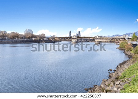 steel bridge on tranquil water with cityscape and skyline of portland