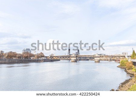 steel bridge on tranquil water with cityscape and skyline of portland