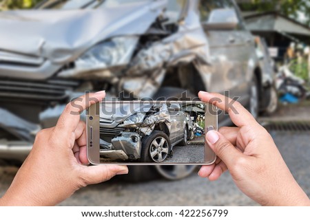Close up hand of woman holding smartphone and take photo of car accident Royalty-Free Stock Photo #422256799