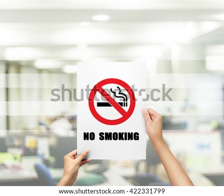 hand holding label paper no smoking at offic