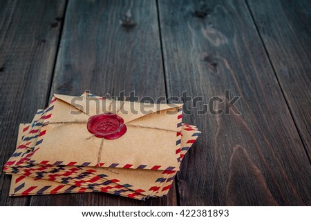 Old envelopes with a wax magic witch stamp on wooden table