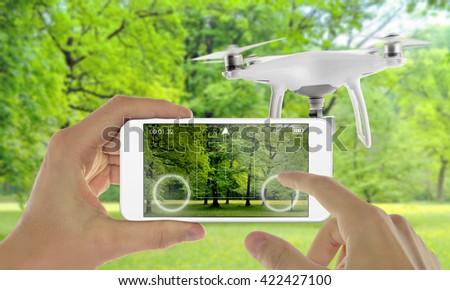 Smart phone control drone with app. Park in background.