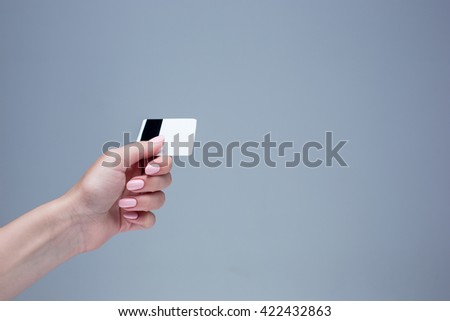 The card in a female hand is on a gray background