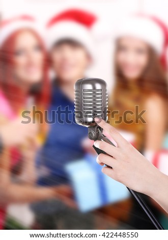 Retro microphone in female hand on blurred people background